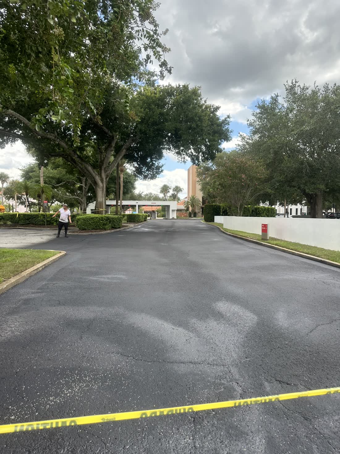Residential driveway after a fresh sealcoat application in front of a brick home